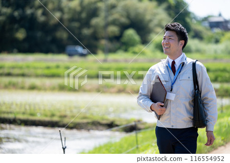 走在稻田路上的商人 116554952