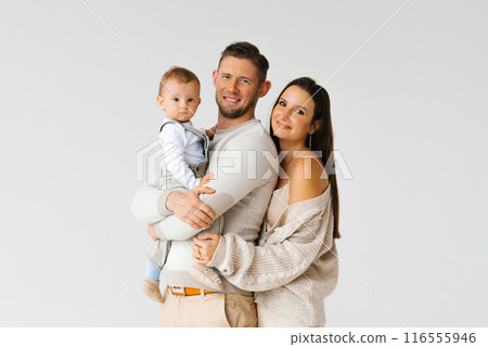 Portrait of a happy young family with a one-year-old son in their arms with copy space 116555946