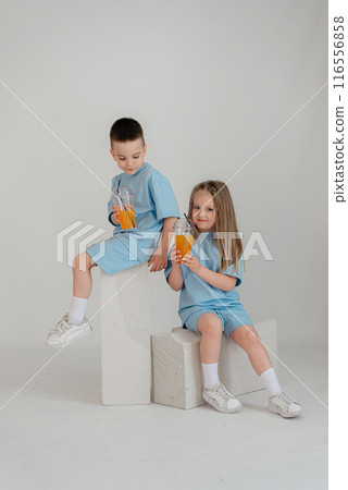 A couple of children in identical costumes have fun in the studio A couple of children in identical costumes have fun in the studio 116556858