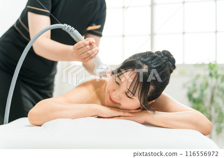 A woman receiving slimming treatment at a beauty salon or relaxation salon (beauty machine, spa) A woman receiving slimming treatment at a beauty salon or relaxation salon (beauty machine, spa) 116556972