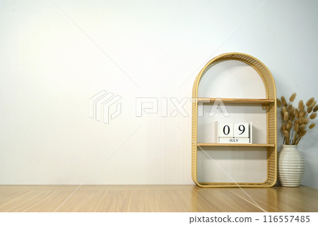 Minimalist interior decor setup with a wooden arched shelf and vase filled with dried pampas grass against a white wall Minimalist interior decor setup with a wooden arched shelf and vase filled with dried pampas grass against a white wall 116557485