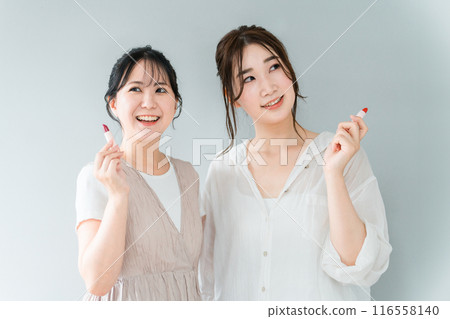 一個女人化妝、與朋友一起準備的化妝形象（口紅、唇彩、化妝品、微笑的亞洲女人） 116558140