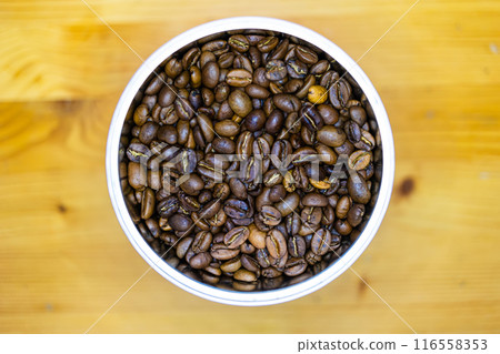 Overhead view of a container filled with roasted coffee beans. Overhead view of a container filled with roasted coffee beans. 116558353
