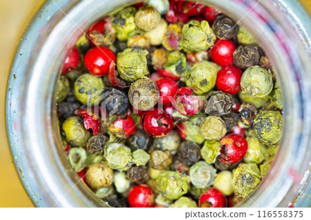 Vibrant mix of red, green, and black peppercorns inside a jar. Vibrant mix of red, green, and black peppercorns inside a jar. 116558375