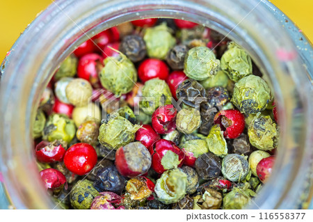 Vibrant mix of red, green, and black peppercorns inside a jar. 116558377