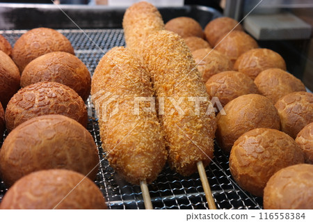 Korean hot dog made by putting sausage on a stick, coating it in batter, and then frying it Korean hot dog made by putting sausage on a stick, coating it in batter, and then frying it 116558384