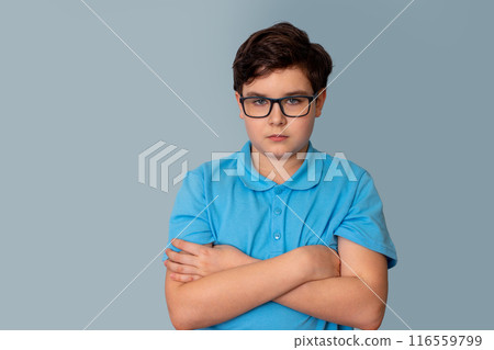 A sad dark-haired boy with glasses,arms crossed on his chest 116559799