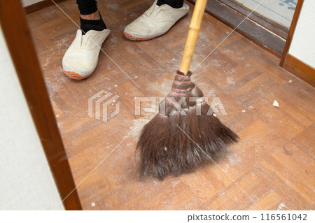 A wallpaper craftsman laying floor tiles on the hallway floor during the renovation of a used house A wallpaper craftsman laying floor tiles on the hallway floor during the renovation of a used house 116561042