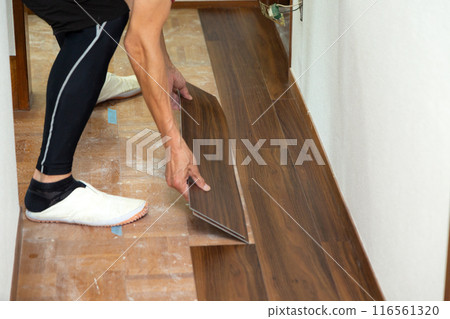 一名布藝工匠在翻新二手房時將地磚貼在走廊地板上。 116561320