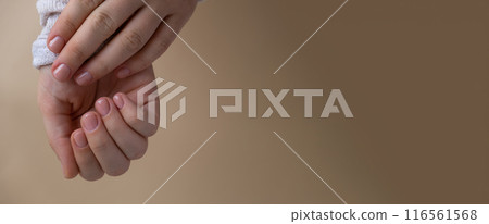 Pastel softness manicured nails on neutral beige background. Woman showing her new manicure in colors of pastel palette. Simplicity decor fresh spring vibes earth-colored neutral tones  116561568