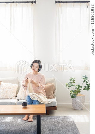 Woman knitting in the living room Woman knitting in the living room 116561958