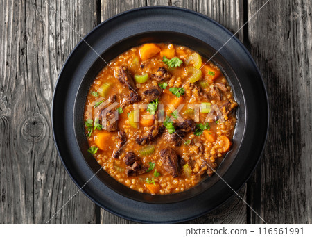 beef barley soup in a bowl, top view 116561991