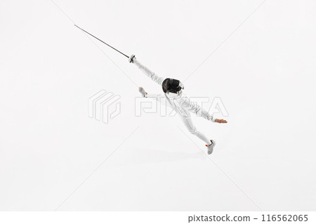 Aerial view of young man, fencer in uniform leaping to attack opponent against white studio background. Activity. 116562065