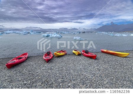 Colorful kayaks resting on a rocky beach awaiting kayakers in iceland Colorful kayaks resting on a rocky beach awaiting kayakers in iceland 116562236