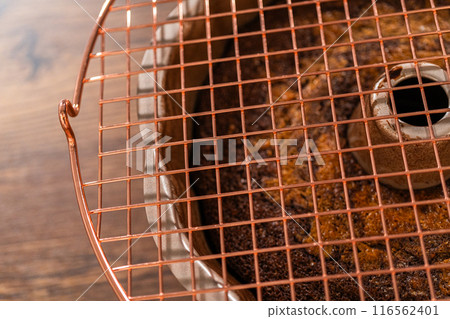 The gingerbread bundt cake cools gracefully on a wire rack, awaiting its sweet caramel frosting. The gingerbread bundt cake cools gracefully on a wire rack, awaiting its sweet caramel frosting. 116562401