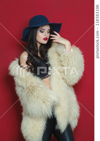 Posing young brunette lady with makeup and long curly hair Posing young brunette lady with makeup and long curly hair 116563106