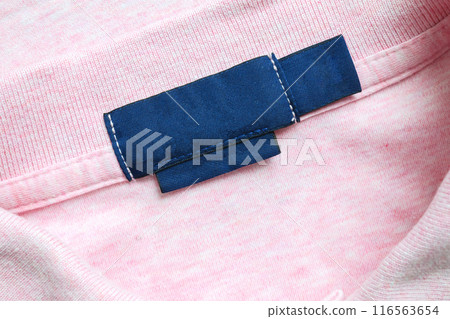 Blank blue laundry care clothes label on pink shirt fabric texture background 116563654