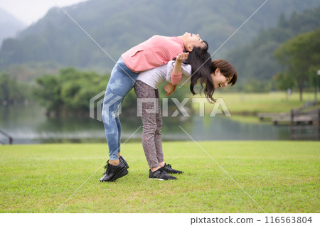 Two women doing stretching exercises 116563804