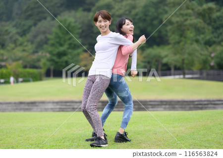 Two women doing stretching exercises 116563824