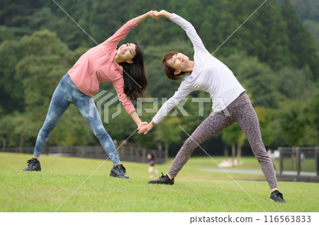 Two women doing stretching exercises 116563833