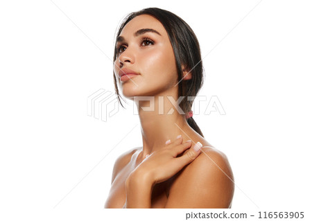 Natural beauty, aesthetics. Portrait of attractive young woman with black hair in ponytail, well-kept skin, plump lips isolated on white background 116563905