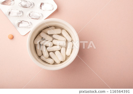 Pills on pink background top view. White capsules, pink pill, empty pills blister. Allergy pill, antibiotics, supplements. Medicine, healthcare concept. Virus(viral), flu diseases. High quality photo 116564391