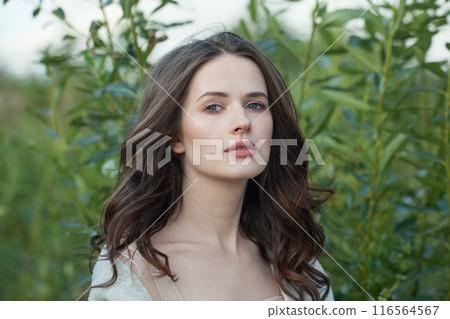 Lovely healthy brunette woman with long hairstyle and fresh skin walking outdoors 116564567