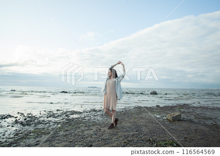 Standing healthy brunette woman with long hairstyle and fresh skin walking outdoors 116564569