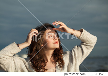 Resting healthy brunette woman with long hairstyle and fresh skin walking outdoors 116564570