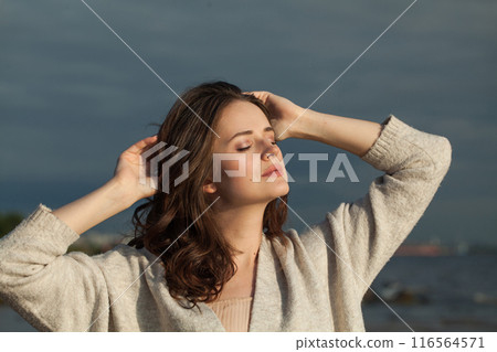 Carefree healthy brunette woman with long hairstyle and fresh skin walking outdoors 116564571