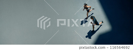 Banner. Aerial view of young people jogging together outdoor on sunny summer day at park. Negative space to insert your text. Banner. Aerial view of young people jogging together outdoor on sunny summer day at park. Negative space to insert your text. 116564692
