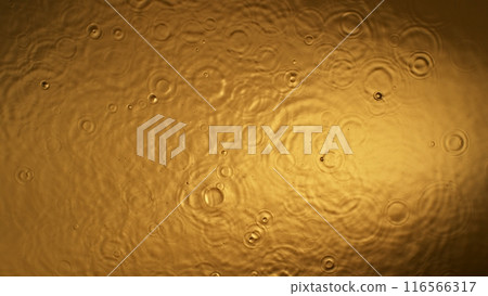 Freeze motion of splashing liquid on golden background Freeze motion of splashing liquid on golden background 116566317