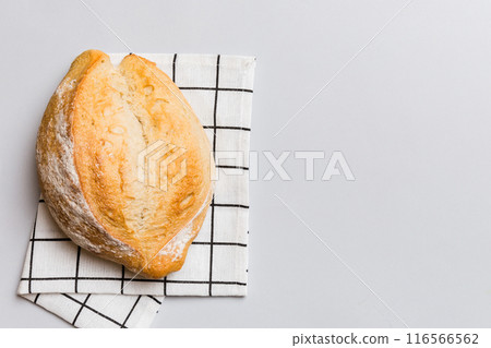 Freshly baked delicious french bread with napkin on rustic table top view. Healthy white bread loaf Freshly baked delicious french bread with napkin on rustic table top view. Healthy white bread loaf 116566562