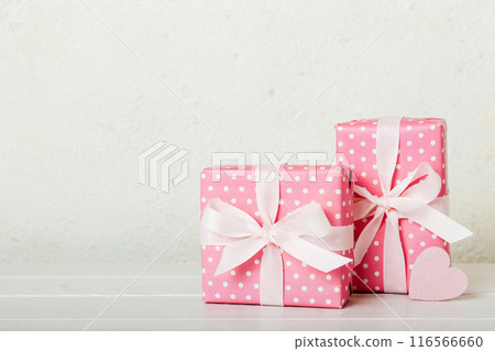 gift box with red bow and red heart on colored background. Perspective view. Flat lay 116566660