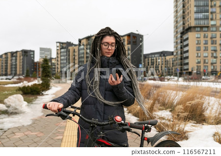 Lifestyle concept, young European woman with informal dreadlocks hairstyle walking around the city 116567211
