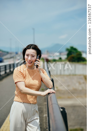 A young lady who makes a phone call on a smartphone A young lady who makes a phone call on a smartphone 116567537
