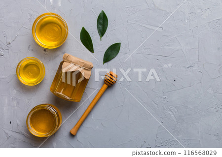 Honey jar with wooden honey dipper on white background top view with copy space. Delicious honey bottle Honey jar with wooden honey dipper on white background top view with copy space. Delicious honey bottle 116568029