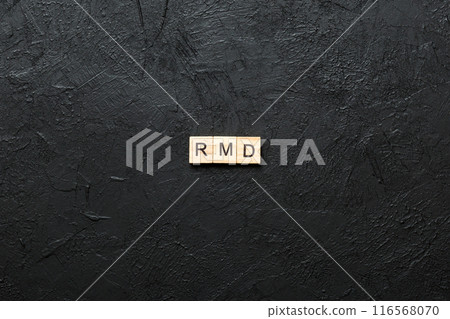 RMD word written on wood block. Required Minimum Distributions text on table, concept 116568070
