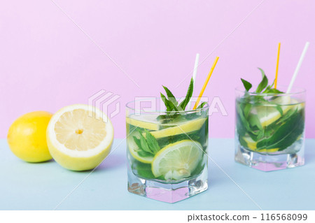 Mojito summer refreshing cocktail with ice and mint. mojito cocktail with lime, lemon and mint in a tall glass with a stick 116568099