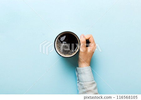 Minimalistic style woman hand holding a cup of coffee on Colored background. Flat lay, top view cappuccino cup. Empty place for text, copy space. Coffee addiction. Top view, flat lay Minimalistic style woman hand holding a cup of coffee on Colored background. Flat lay, top view cappuccino cup. Empty place for text, copy space. Coffee addiction. Top view, flat lay 116568105