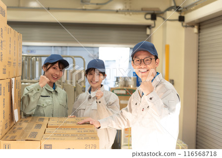 Three men and women working in a warehouse 116568718
