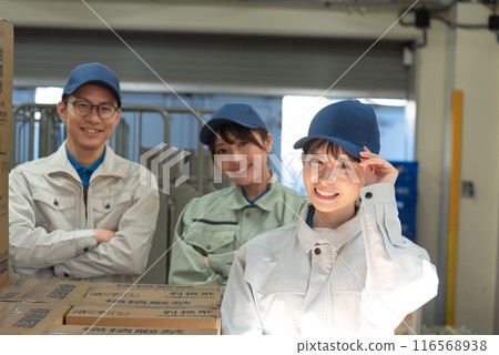 Three men and women working in a warehouse 116568938