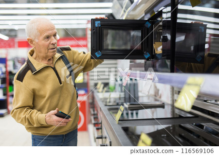 Elderly man choosing microwave oven in showroom of electrical appliance store Elderly man choosing microwave oven in showroom of electrical appliance store 116569106