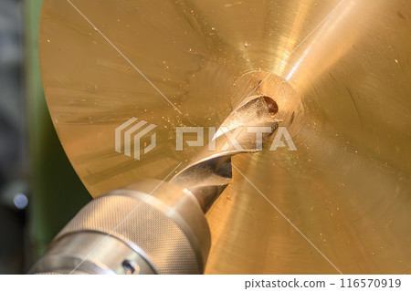 The hole drilling process on brass material parts by lathe machine. 116570919