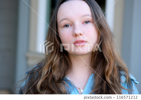 Young girl student smiling near university. Cute girl student holds books. Learning, education concept 116571212