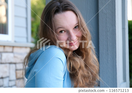 Young girl student smiling near university. Cute girl student holds books. Learning, education concept 116571213