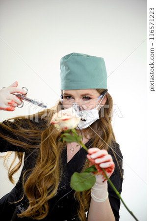 Operation on the layout . Young woman learning to operate on a flower on a rose using a scalpel and an injection 116571223