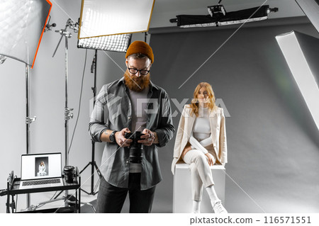 Professional photo shoot setup with photographer and model for artistic or commercial needs Professional photo shoot setup with photographer and model for artistic or commercial needs 116571551