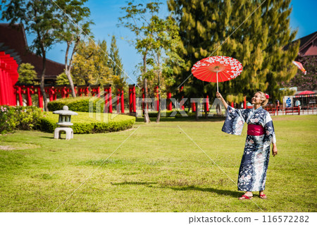 Asian girl in kimono and umbrella in Japanese theme park Hinoki Land in Chai Prakan District, Chiang 116572282