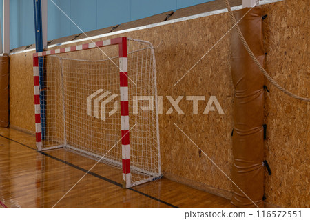 Indoor Sports Goalpost in Gymnasium with Wooden Wall, Red and White Net for Team Practices. Indoor Sports Goalpost in Gymnasium with Wooden Wall, Red and White Net for Team Practices. 116572551